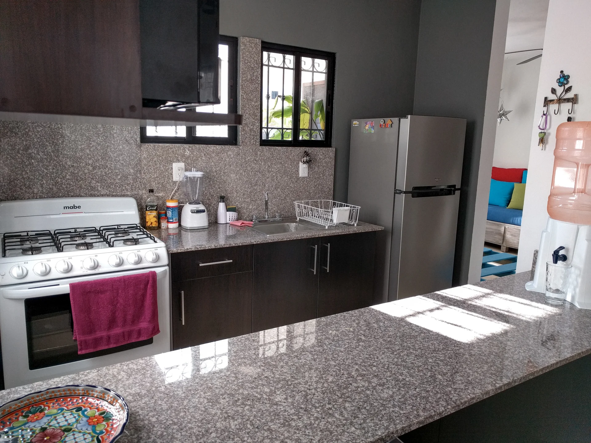 Cocina integral con cubierta de granito, estufa y refrigerador en La Casa Turquesa