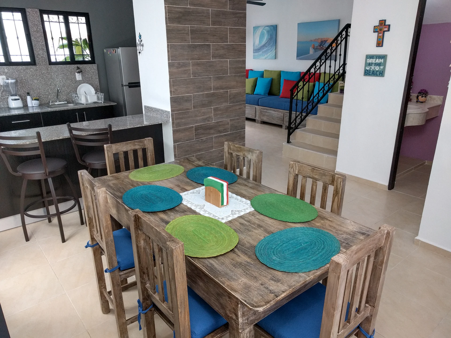 Comedor familiar de madera rústica y barra desayunadora en La Casa Turquesa