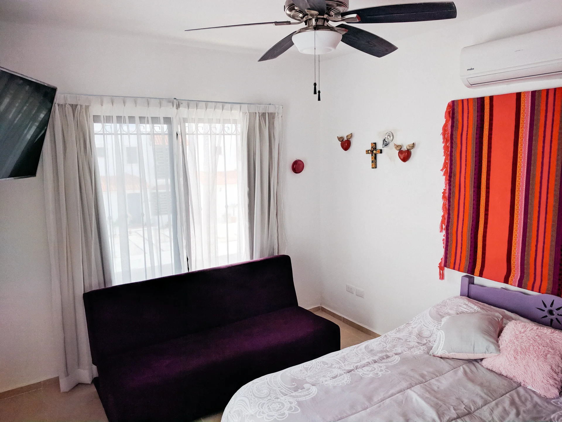Recámara climatizada en La Casa Turquesa con cama, sofá descanso, TV y aire acondicionado